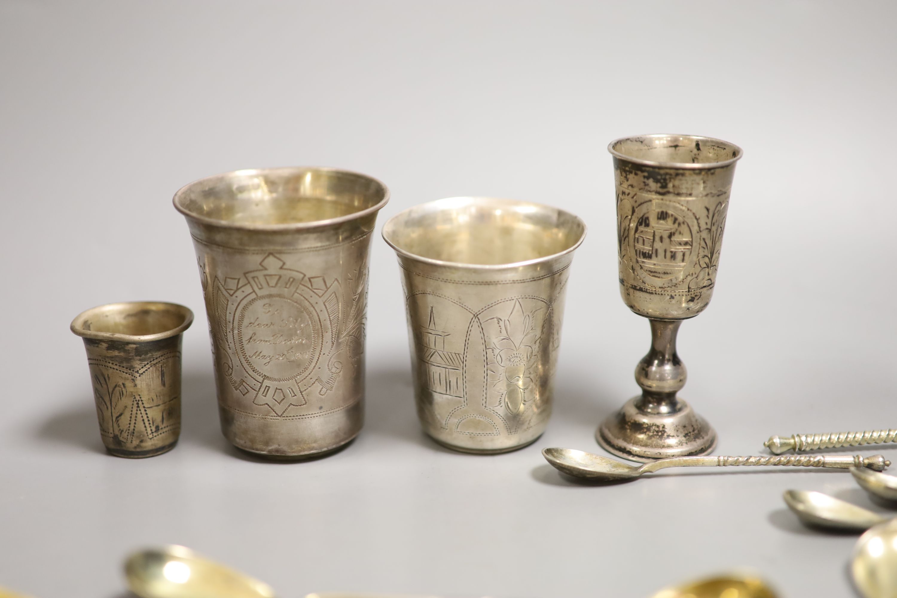 Four assorted 19th century Russian 84 zolotnik small beakers, largest 93mm and twenty five similar tea or coffee spoons including a set of eight with niello decoration